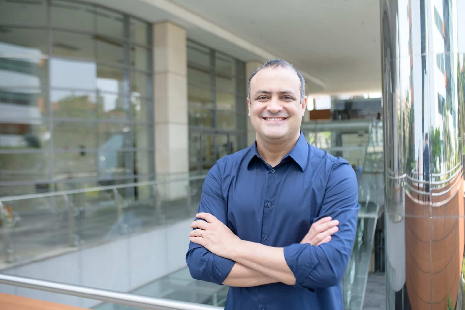 Homem sorrindo com os braços cruzados