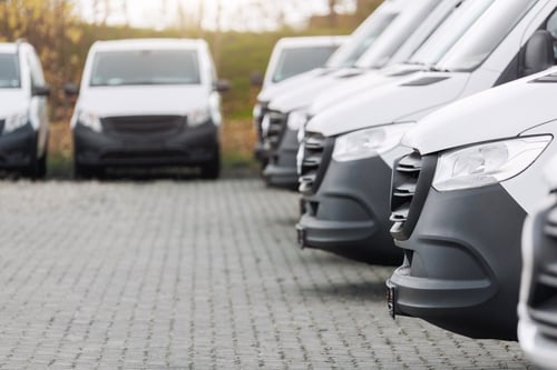 Veículos comerciais alinhados em estacionamento, representando frota empresarial e logística.