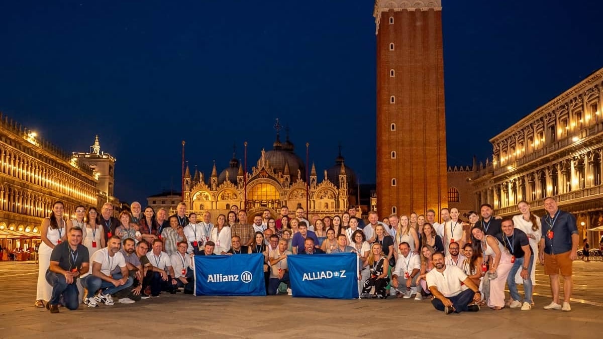 Corretores parceiros e colaboradores da Allianz Seguros reunidos em frente a um monumento histórico na Itália.