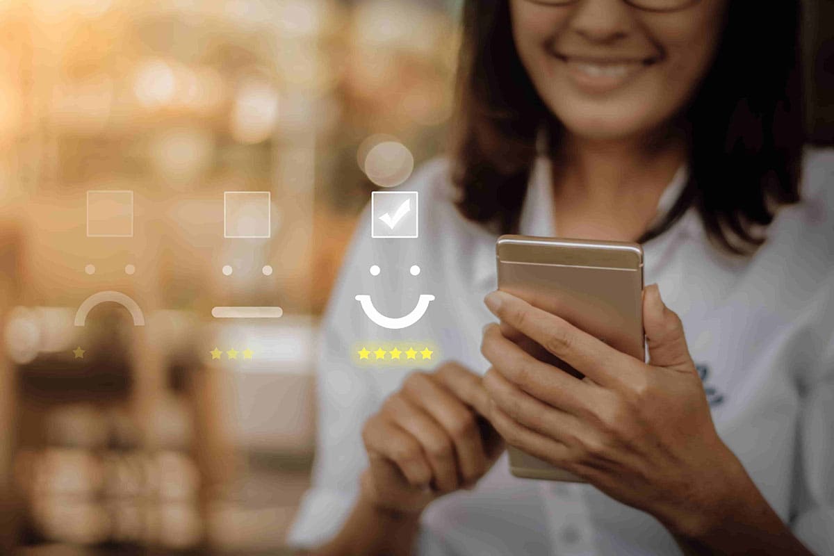 Mulher sorrindo ao usar o celular, simulando a jornada de atendimento de um cliente da Allianz Seguros.