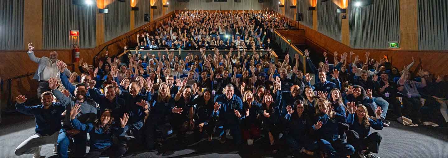 Auditório com corretores reunidos em evento corporativo da Allianz.