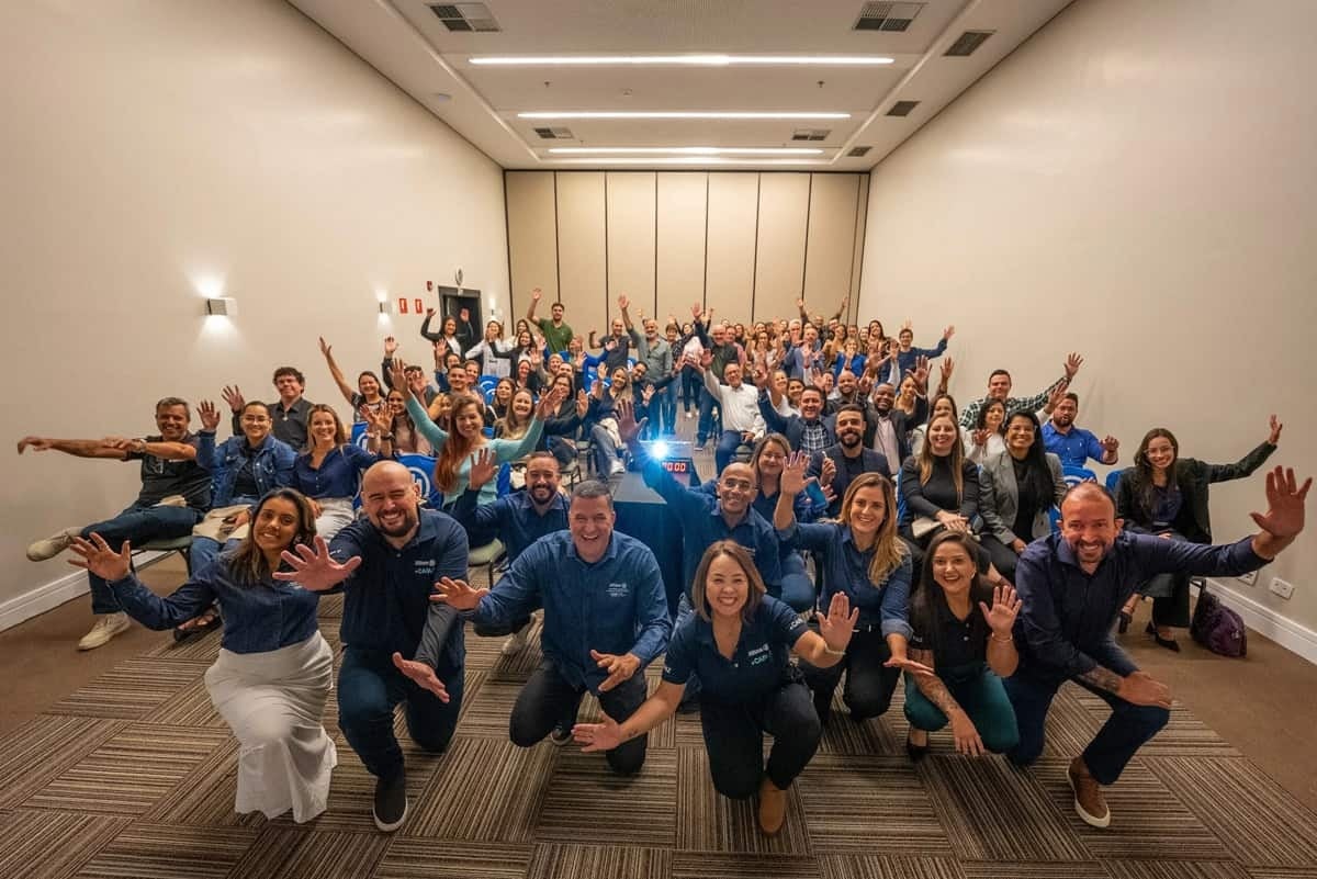 Corretores reunidos em sala comemorando em um evento sobre seguro de vida.