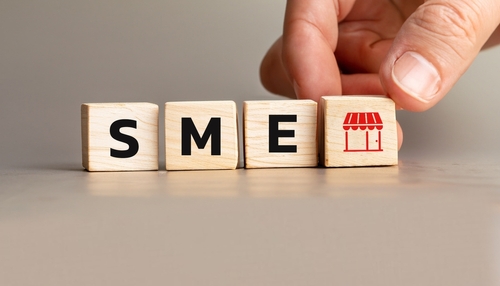 Blocos de madeira formando a sigla SME representando pequenas e médias empresas.