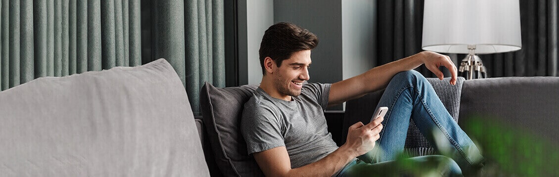 Imagem de um homem com celular na mão para ilustrar página que fala sobre o app "Allianz Cliente Auto"